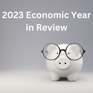 white piggybank with glasses grey background and 2023 Economic Year in Review text