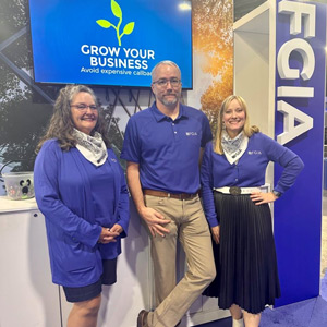 FGIA staff in booth at GlassBuild with FGIA and Grow Your Business sign in the background
