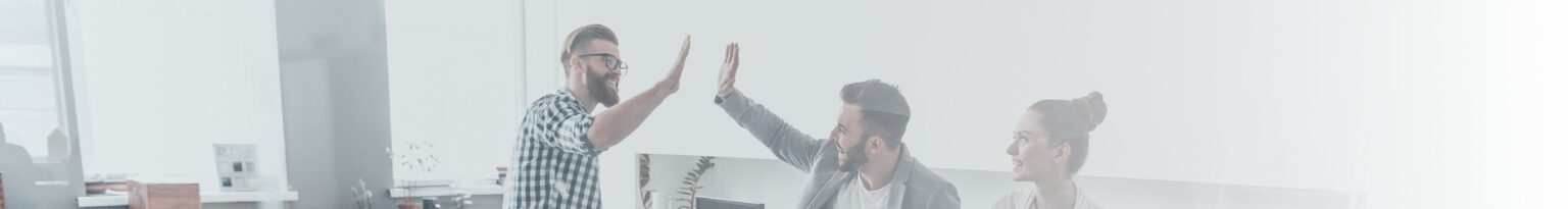 Three adults in a office - two men high-fiving