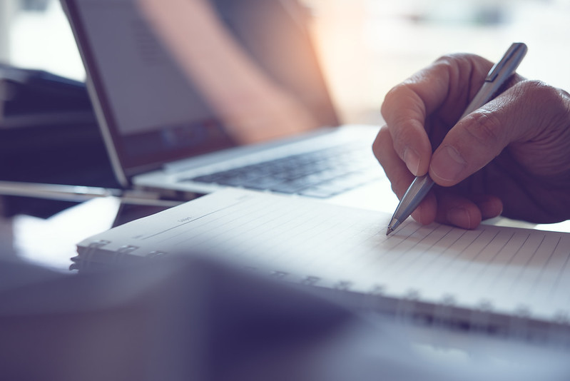 Close-up of a person writing on a notebook